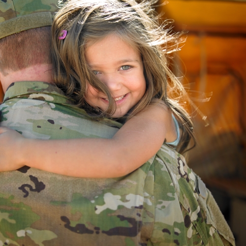 service member holding smiling child