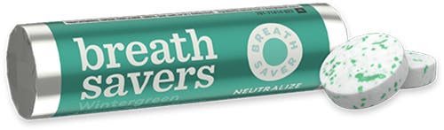 roll of breath savers wintergreen beside pair of unwrapped ice breakers mints