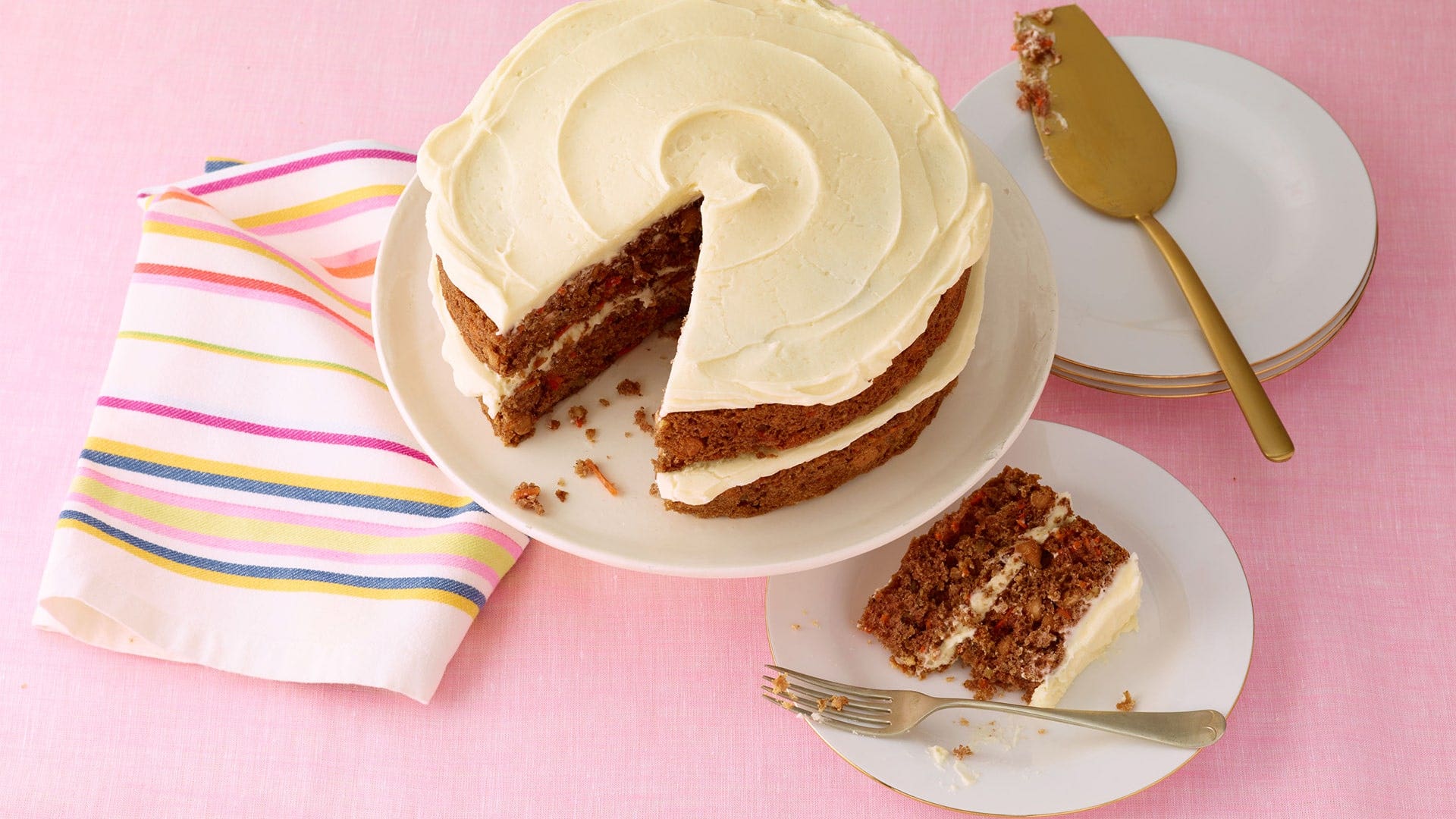 whole carrot cake with single slice on plate