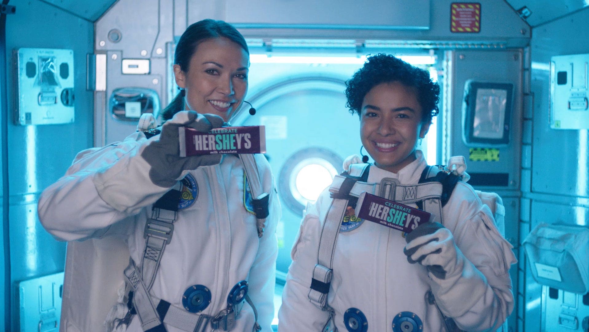 Two women holding HERSHEY'S Bar in space