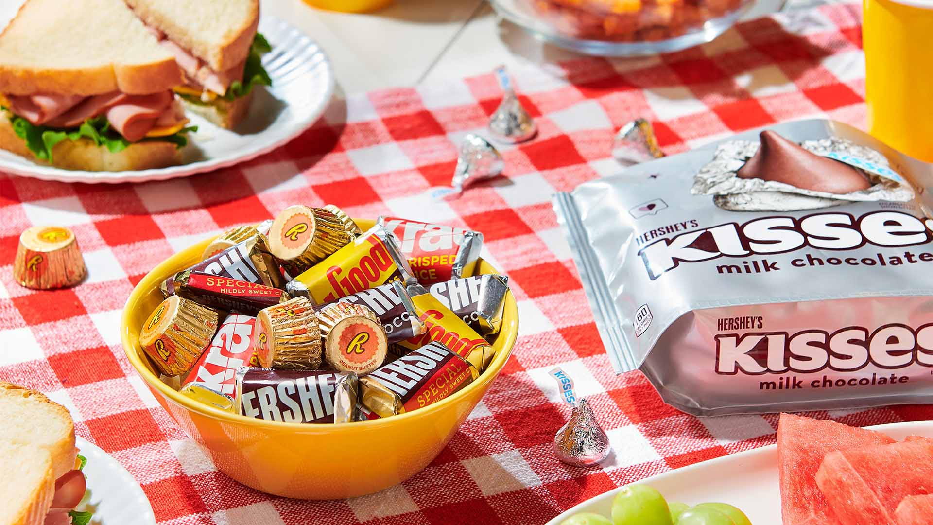 picnic table spread with assorted hersheys candy and sandwiches