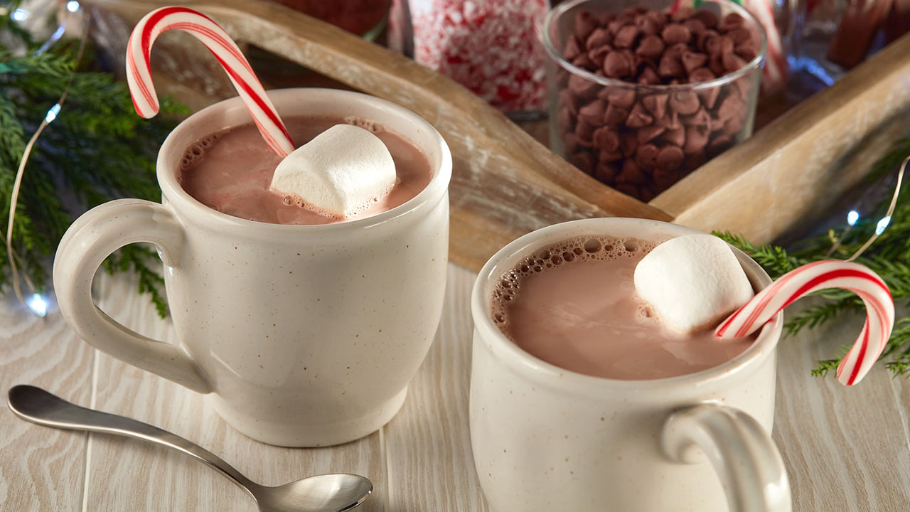 two glass mugs full of hot cocoa