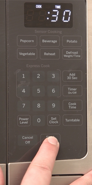 person setting cook time on a microwave