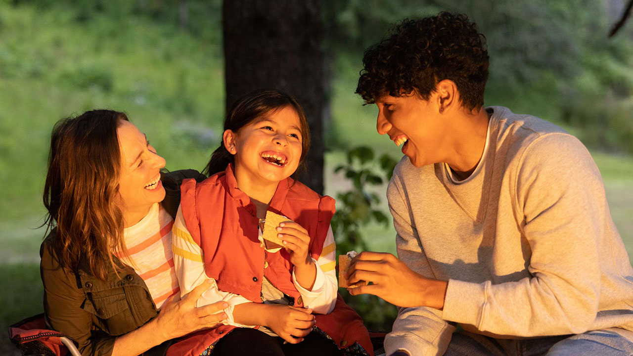 family enjoying smores around the campfire