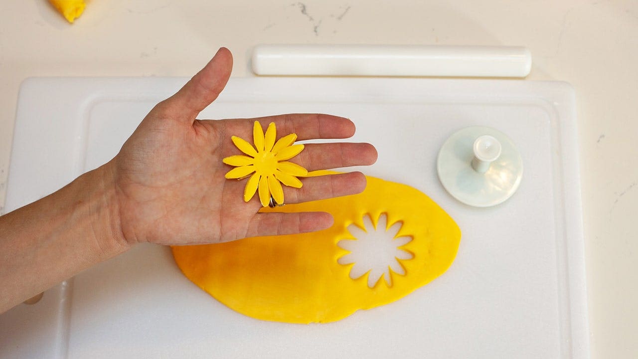 cutting out daisy shapes using fondant cutter