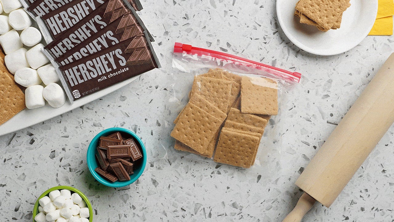 graham crackers in a plastic bag crushed by rolling pin