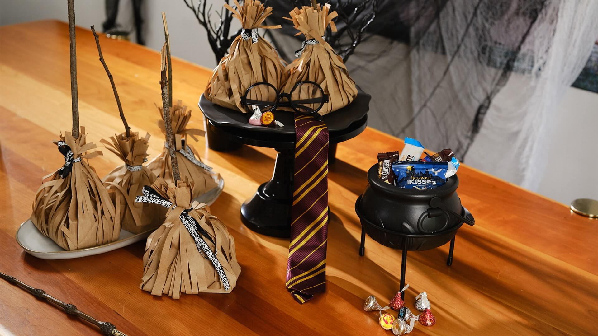 harry potter broomstick treat bags on table with harry potter themed decor