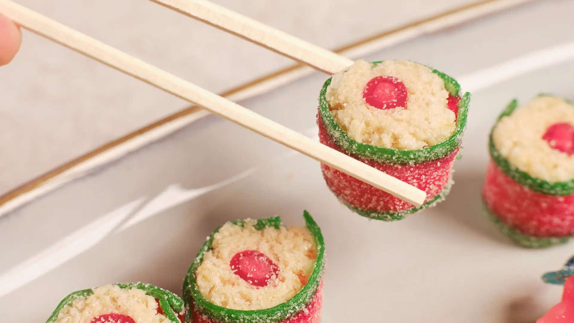 candy sushi being eaten with chopsticks