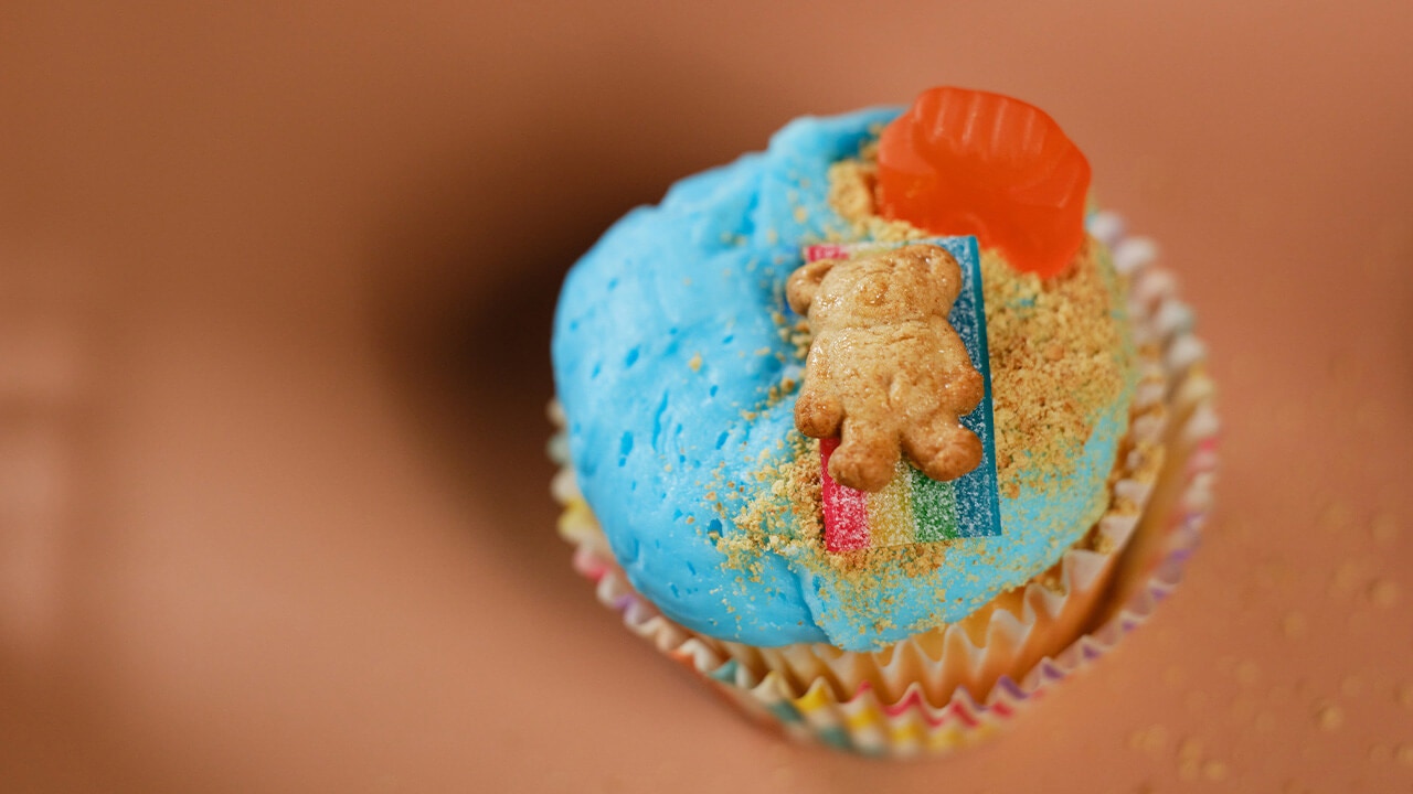 placing teddy bear graham cracker on top of the sour strips candy piece