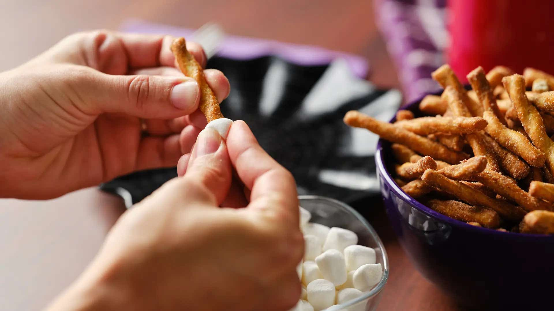 putting marshmallows on the ends of pretzel twists