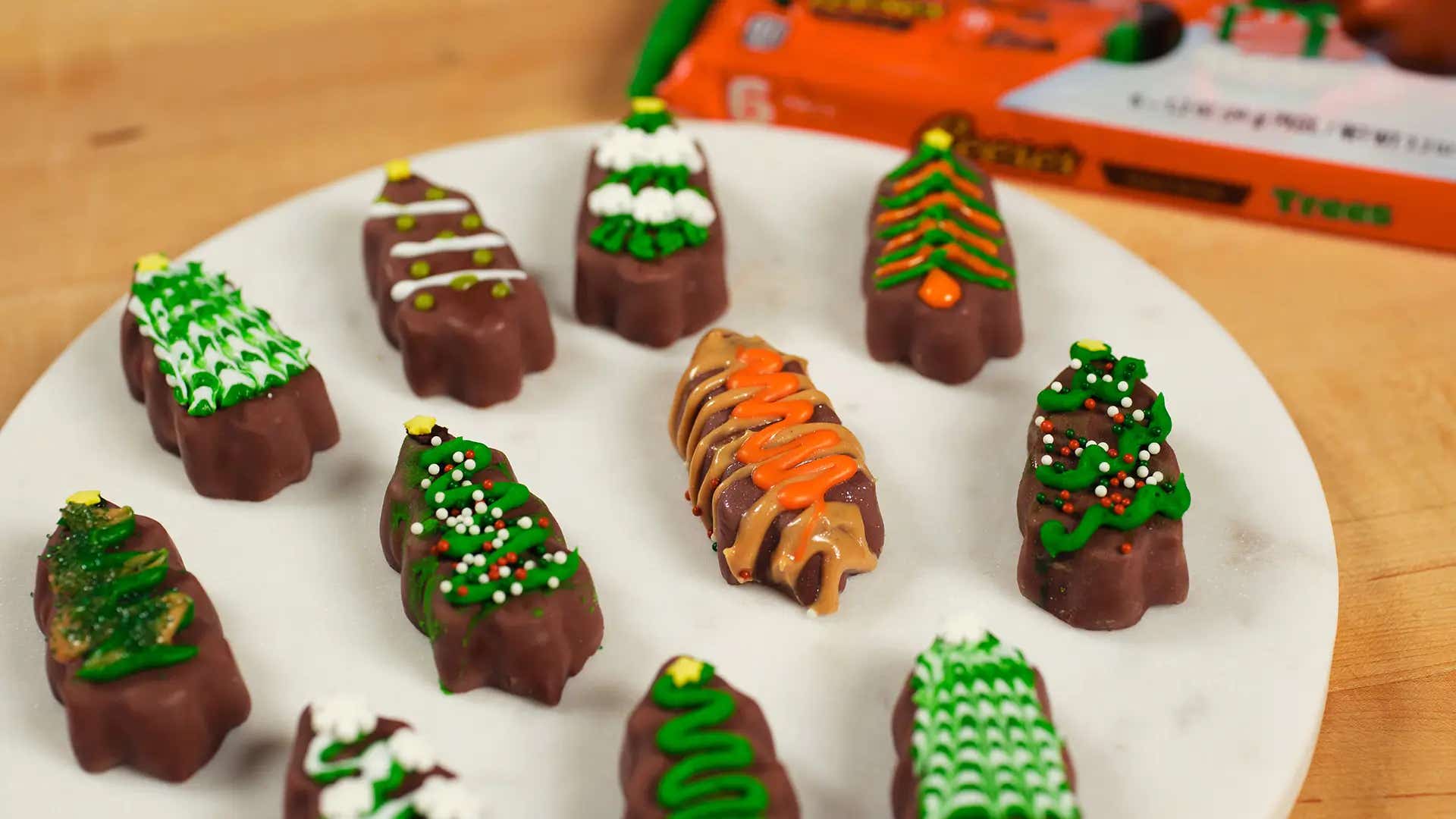 reeses trees decorated with icing and sprinkles on a marble board