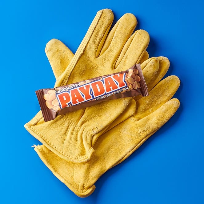 payday candy bar on top of a pair of gloves