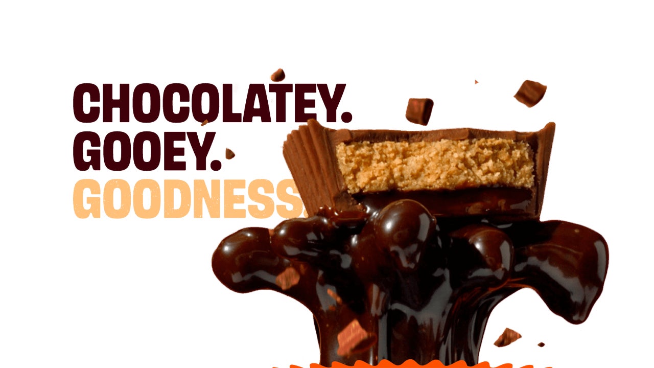 reeses chocolate lava peanut butter cup lifted up into the air from an eruption of liquid chocolate