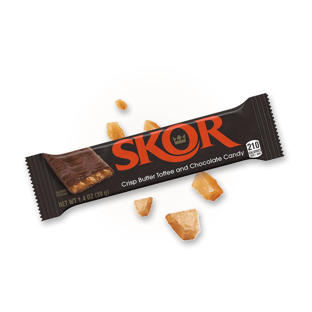 fully wrapped skor crisp butter toffee and chocolate candy bar beside toffee bits