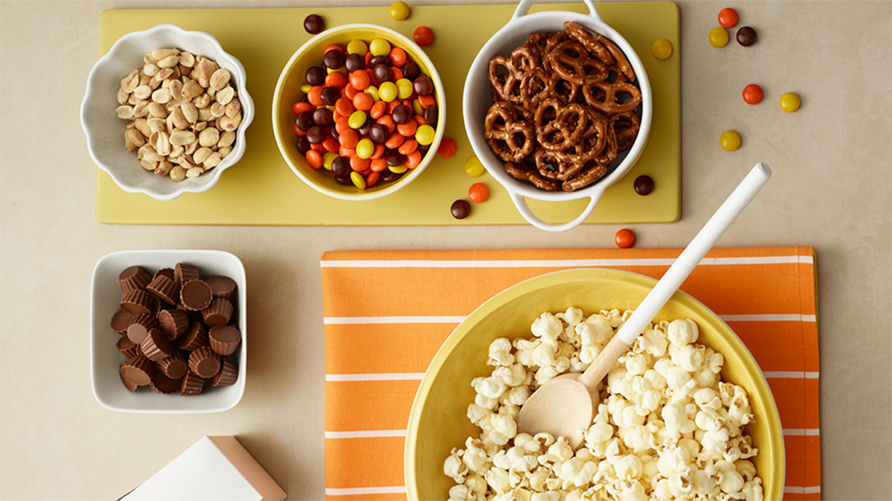 bowls full of popcorn and assorted salty and sweet toppings