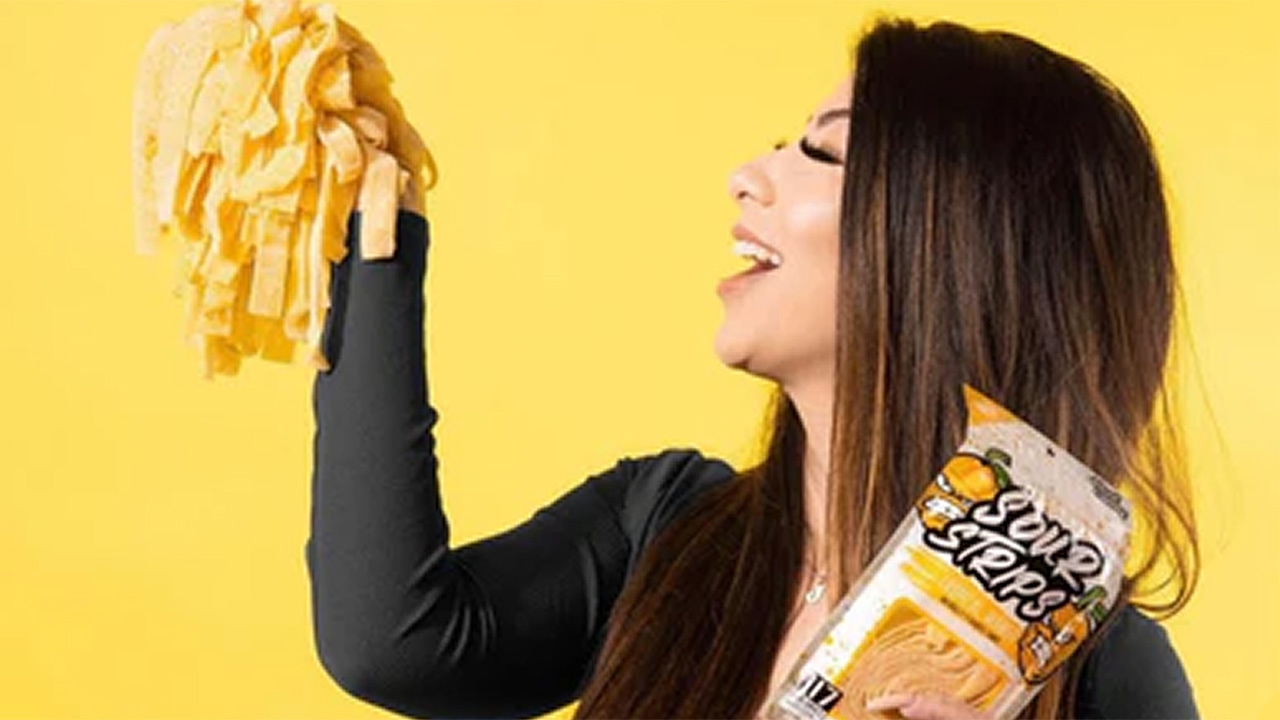 woman holding up sour strips tropical mango flavored chewy candy