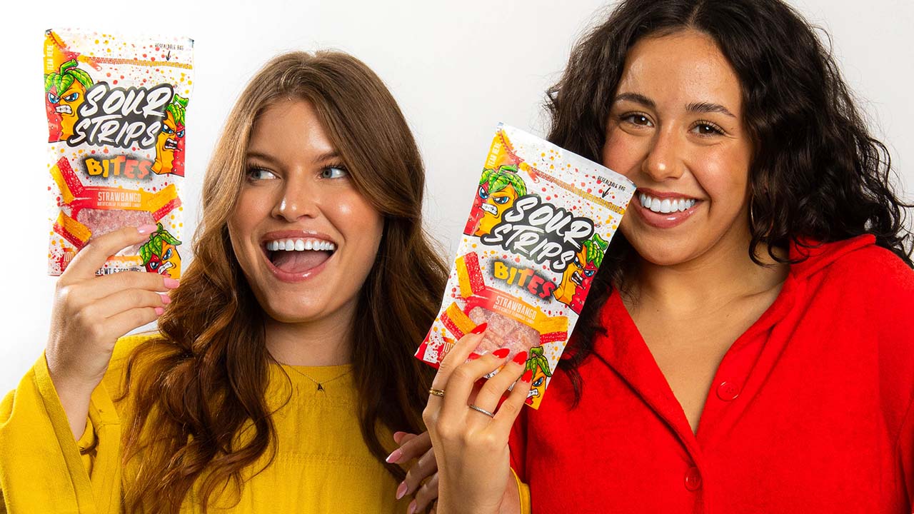 women holding up bags of sour strips bites flavored chewy candies