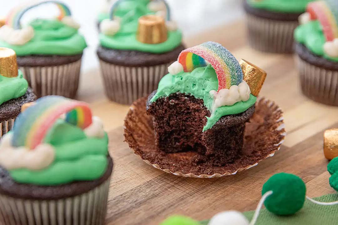 batch of chocolate cupcakes topped with sour strips rainbow flavored chewy candy