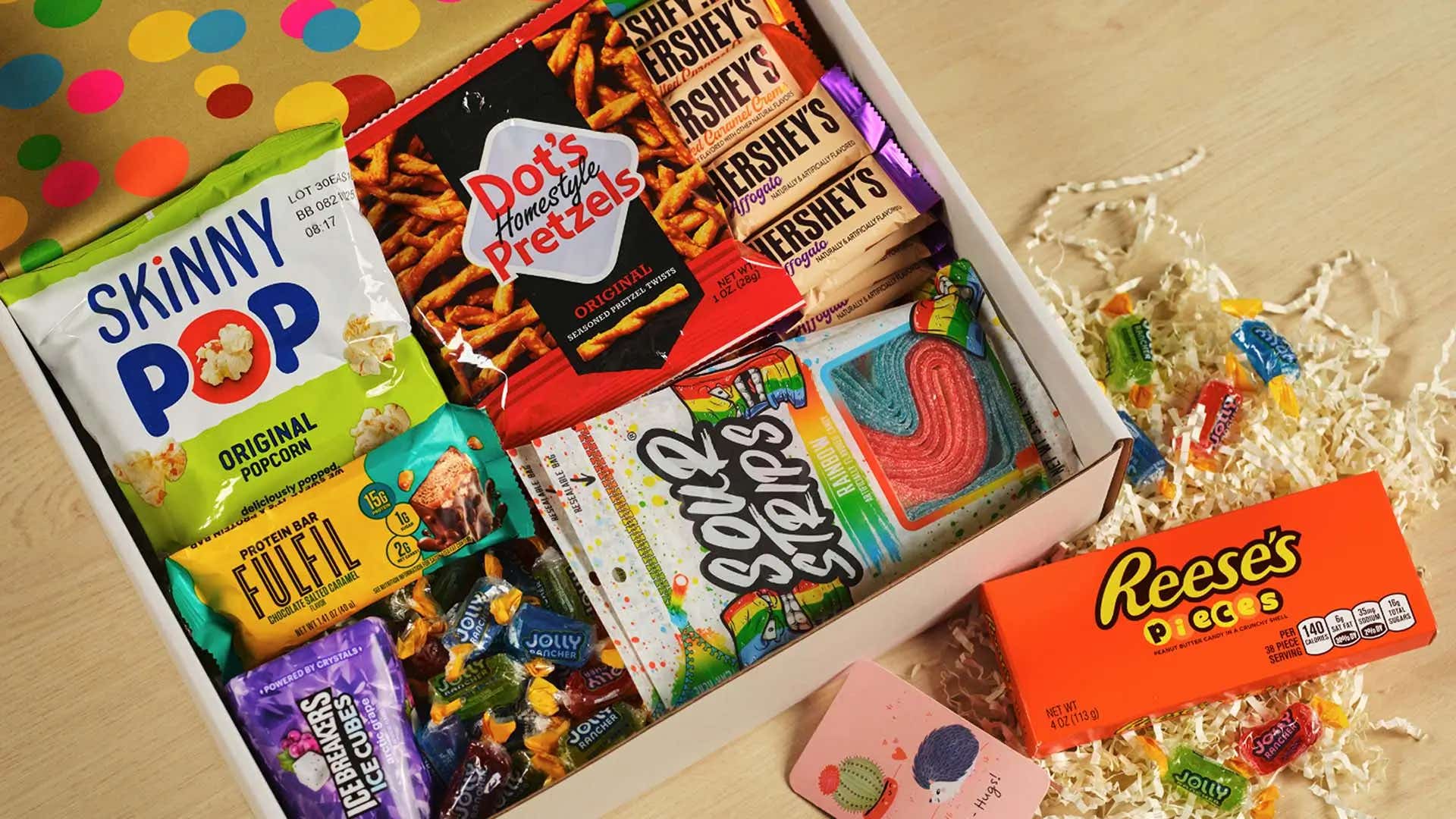 care package filled with an assortment of hersheys candies, snacks, and protein bars