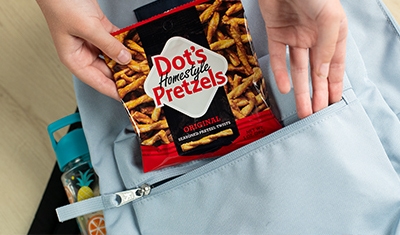 bag of dots pretzels being put in a backpack