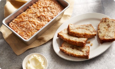 banana bread loaf next to plate of bana bread slices