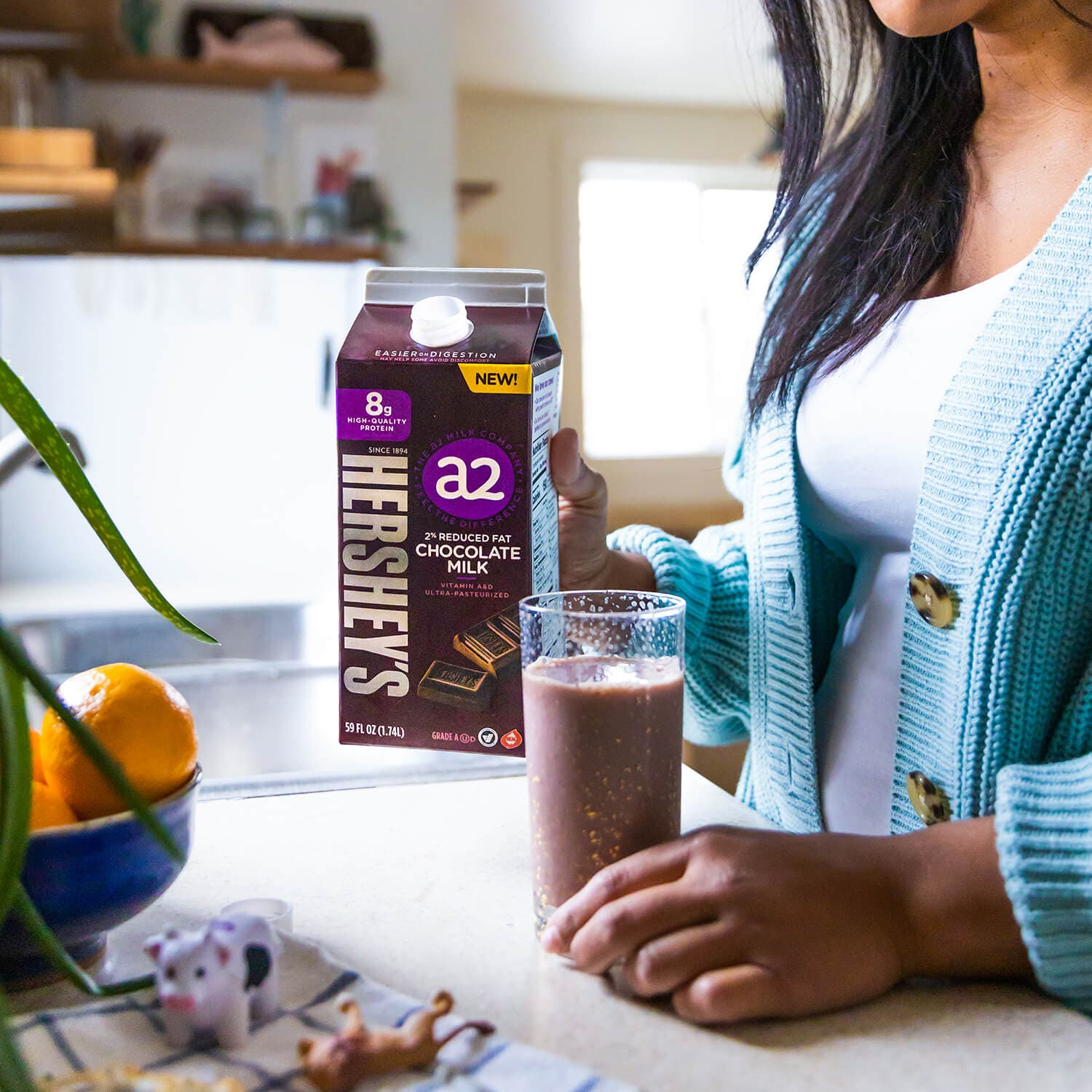 Woman pouring glass of HERSHEY'S a2 Milk Chocolate Milk