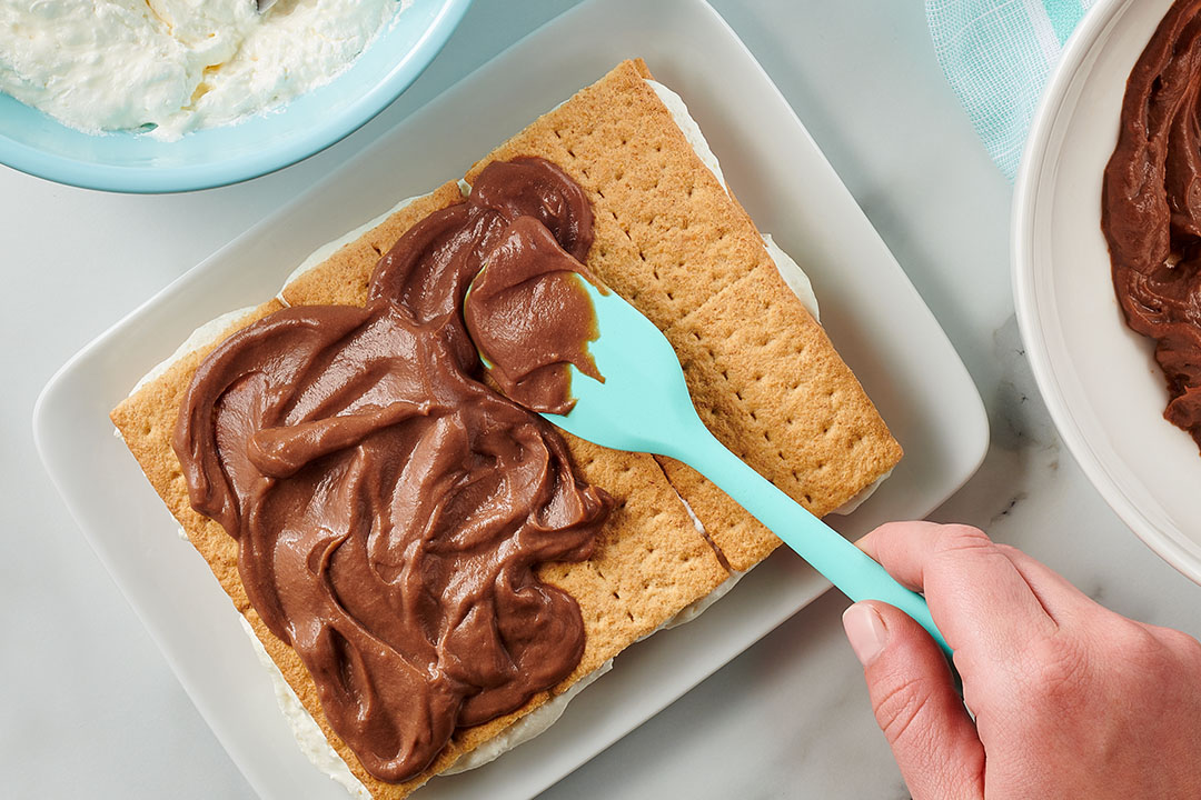 smores cake being assembled on a plate