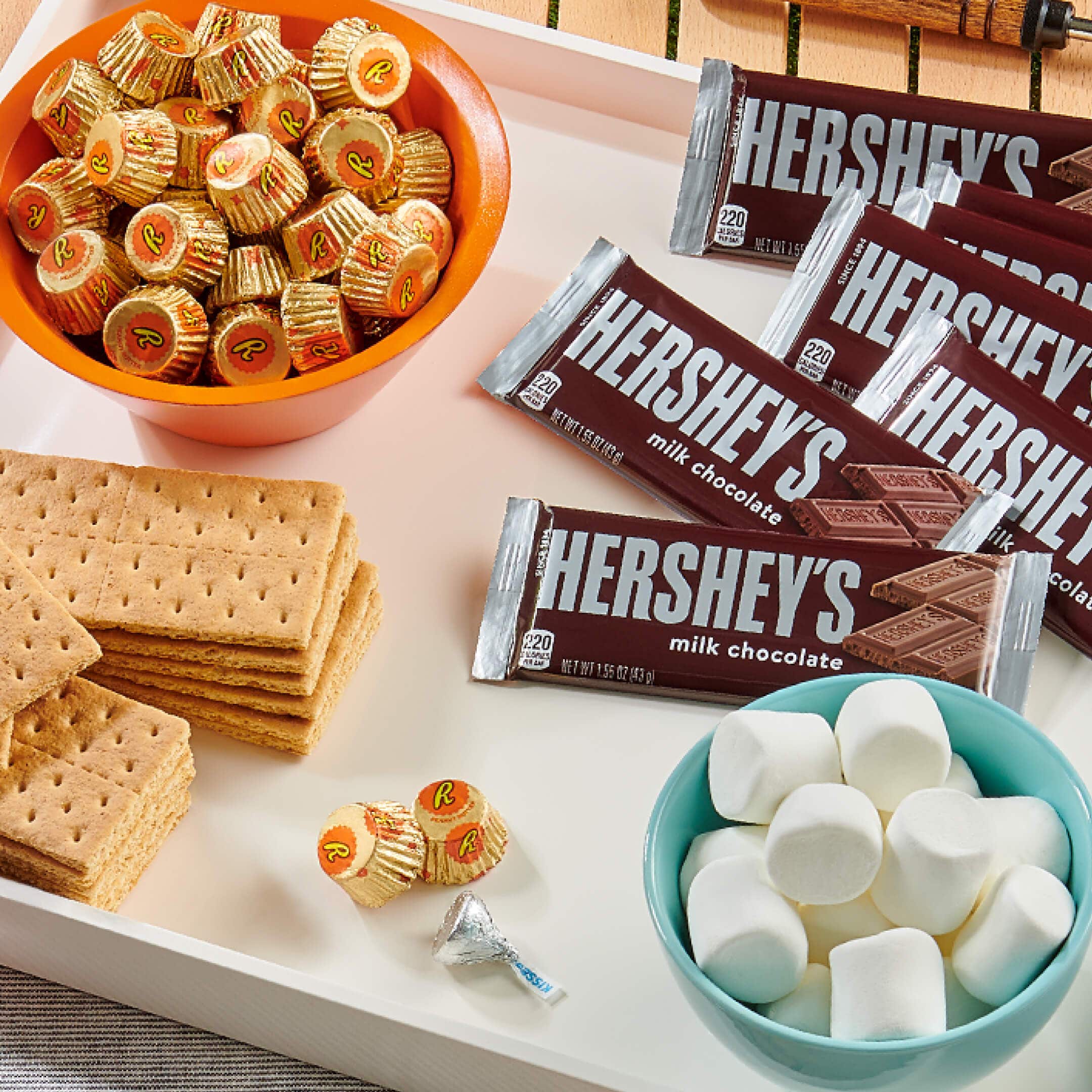 party tray with smores ingredients and a bowl of reeses cups