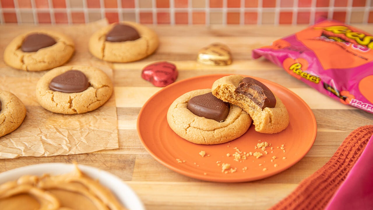 freshly baked reeses heart cookies, one with a bite taken from it