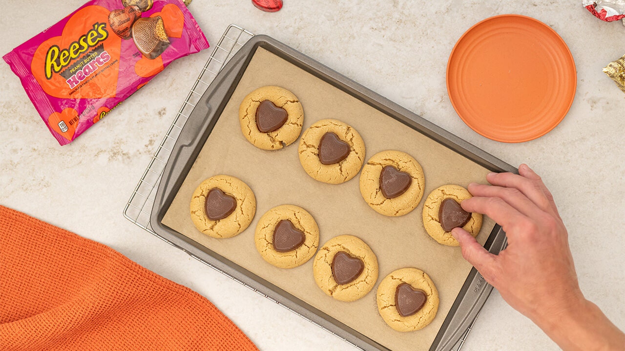reeses hearts pressed into freshly baked cookies