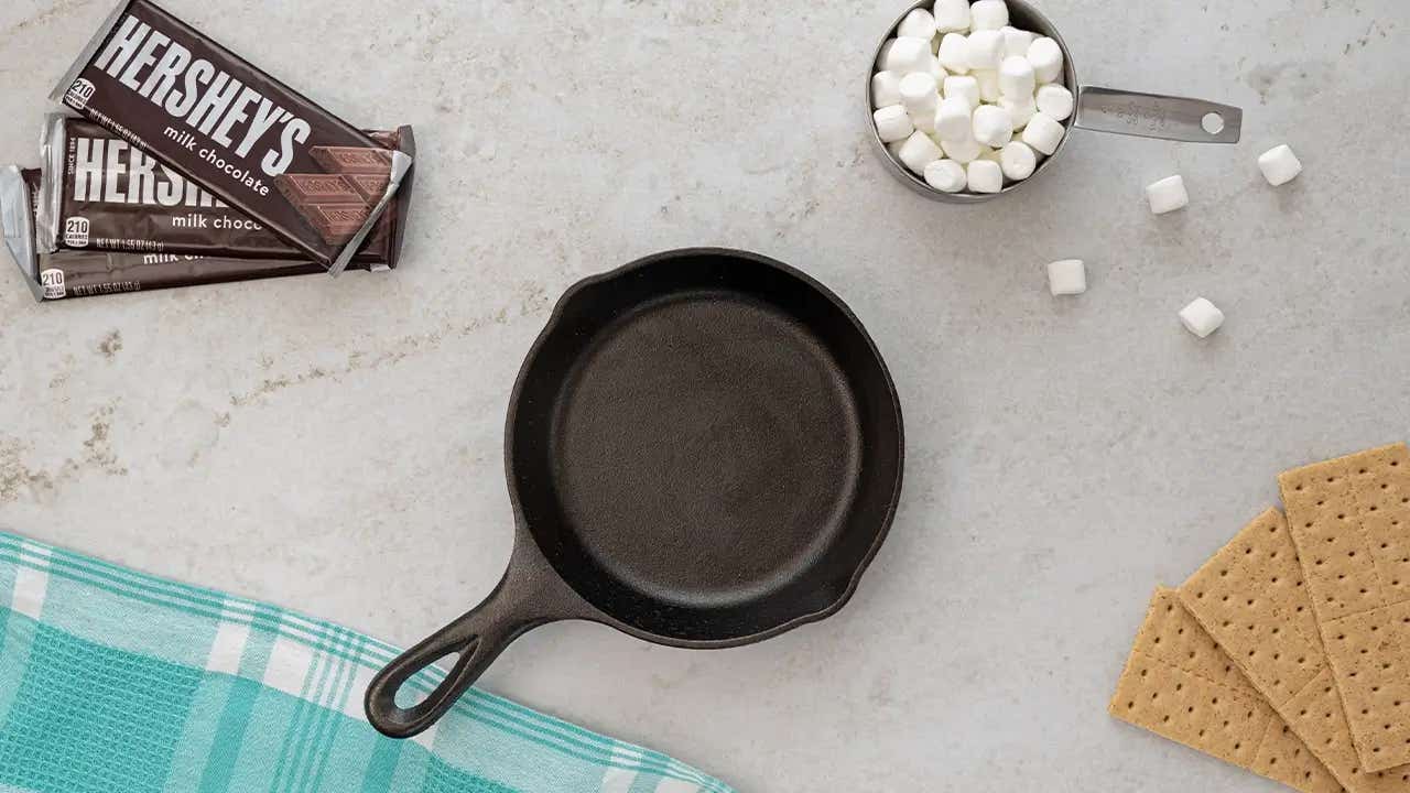 skillet beside hersheys milk chocolate candy bars, marshmallows, and graham crackers