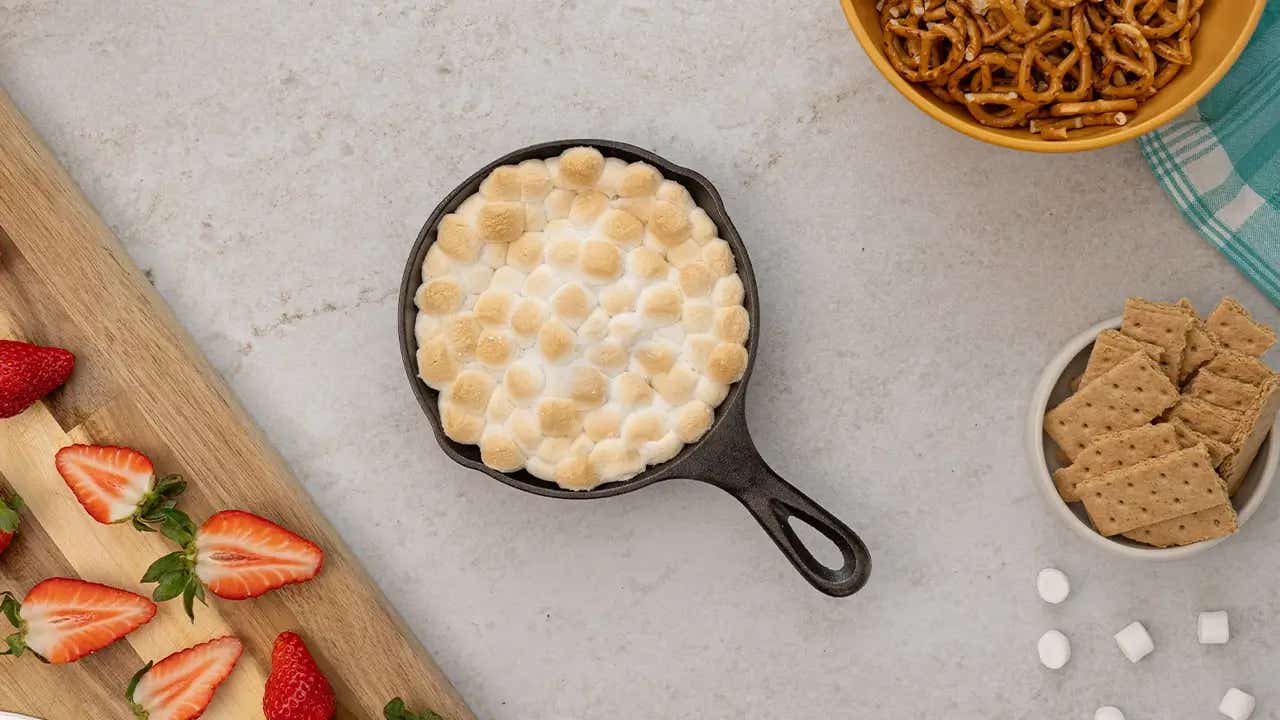 smores skillet dip ready to serve with fruit, snacks, and graham crackers