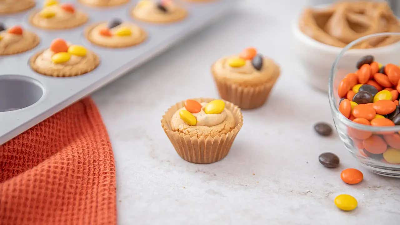muffin tin with freshly baked reeses pieces peanut butter temptations