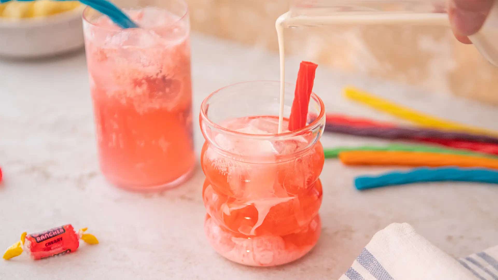 two glasses of cherry vanilla dirty soda with twizzlers rainbow twists and jolly ranchers