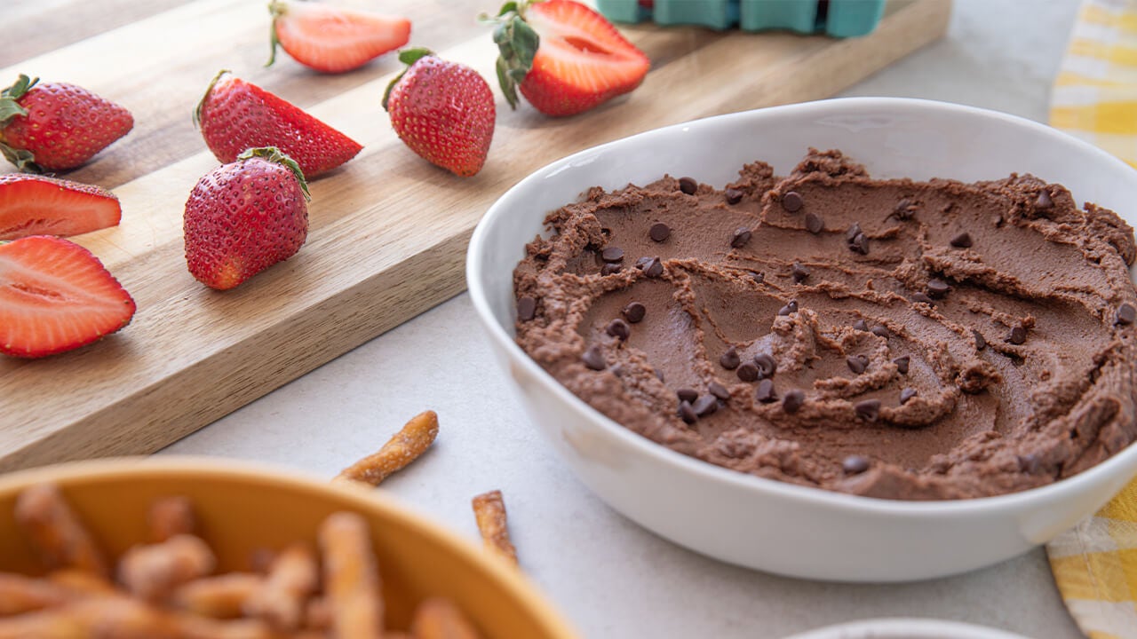 strawberries and pretzels by bowl of chocolate hummus