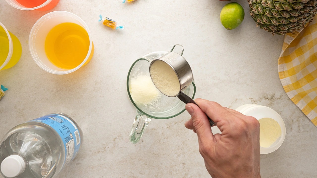 person adding powered lemonade mix into the pitcher