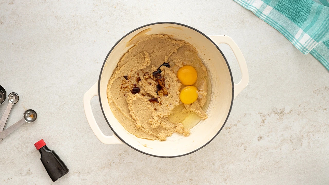 adding vanilla extract and eggs into the cookie mix
