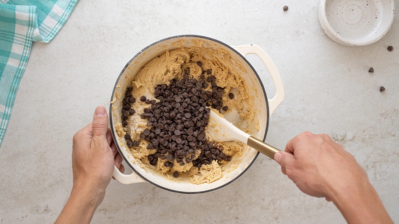 stirring hersheys semi sweet chocolate chips into the cookie mix