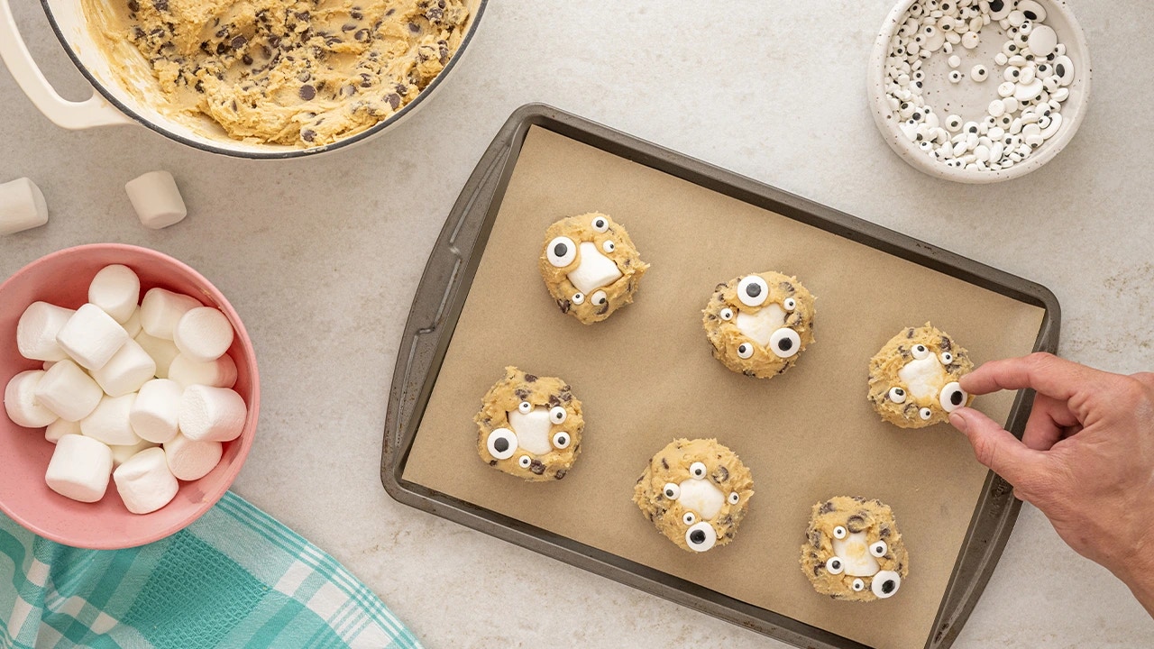 adding candy eyeballs onto the formed cookies