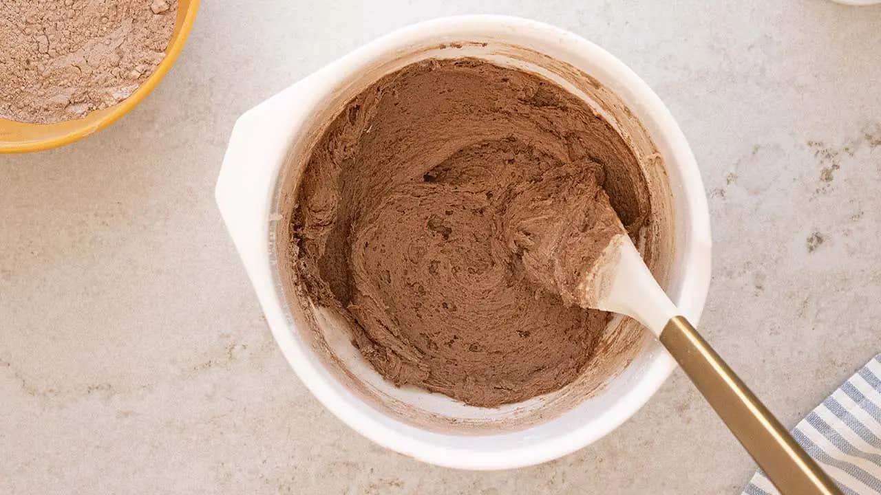 chocolate doughnut dough in mixing bowl with spatula