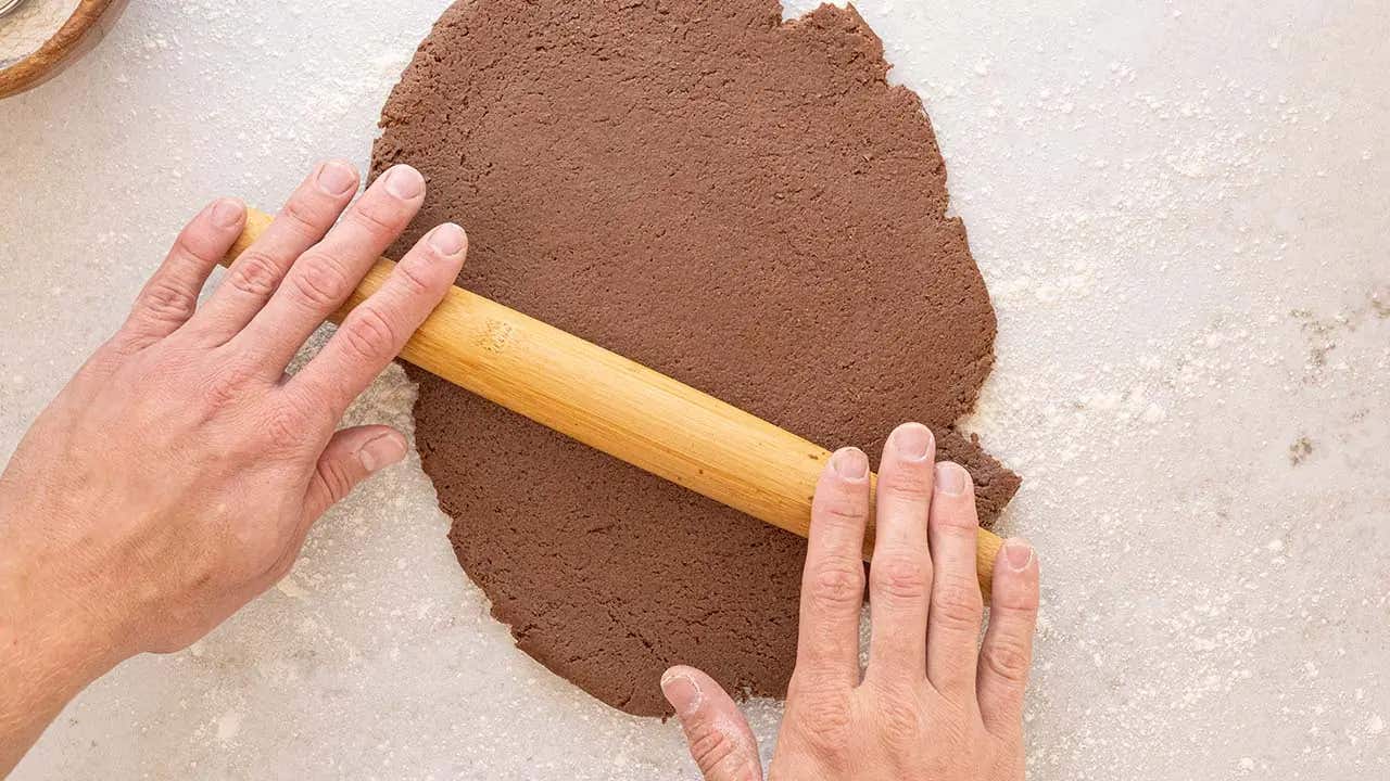 rolling out chocolate doughnut dough with rolling pin