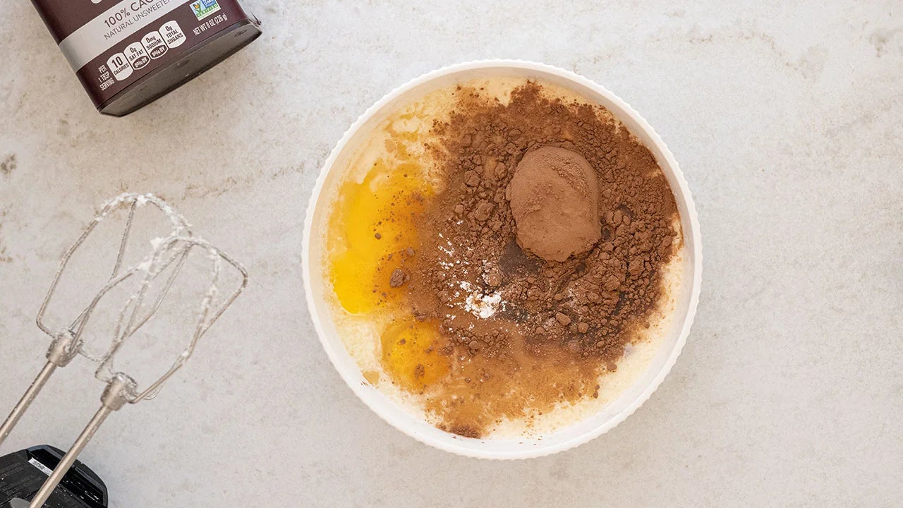 eggs, cocoa and evaporated milk added to butter and sugar mixture in bowl