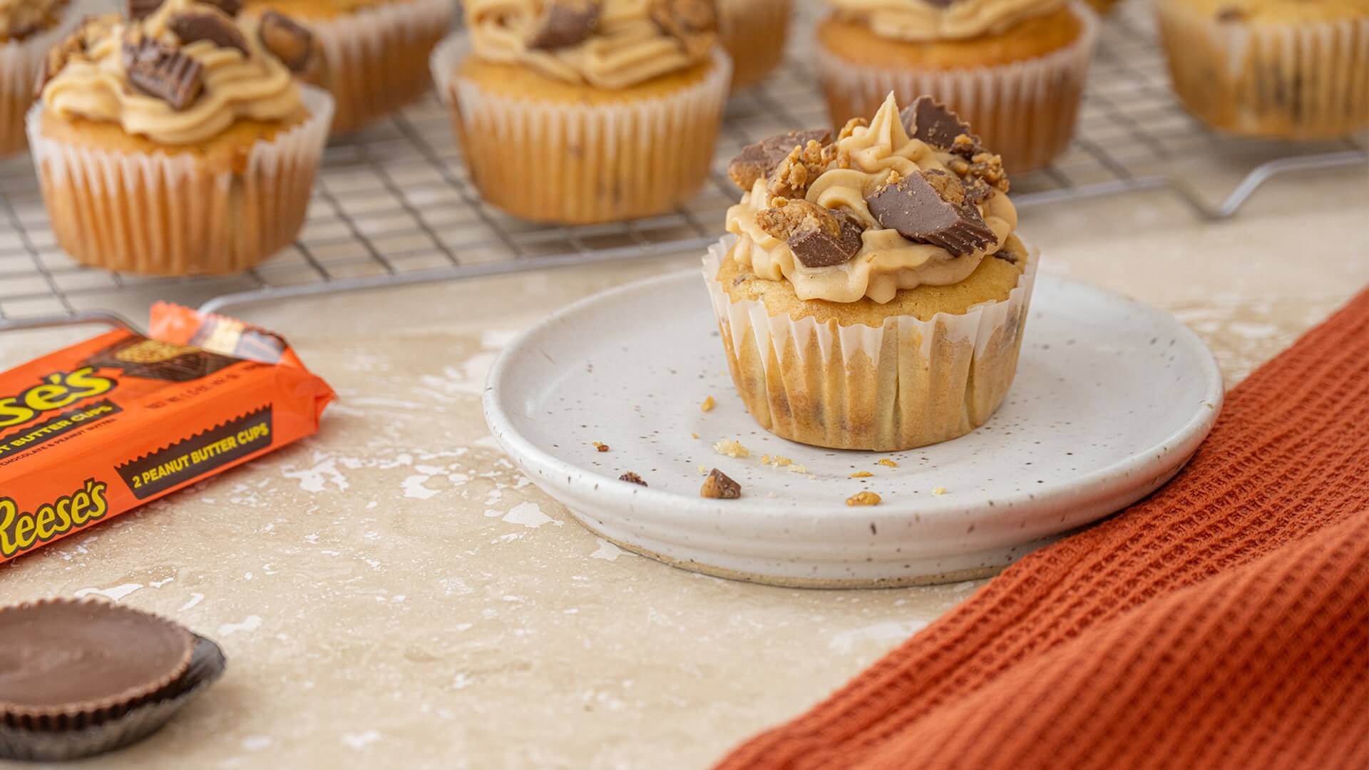 cooling rack full with reeses peanut butter cup crumble cupcakes
