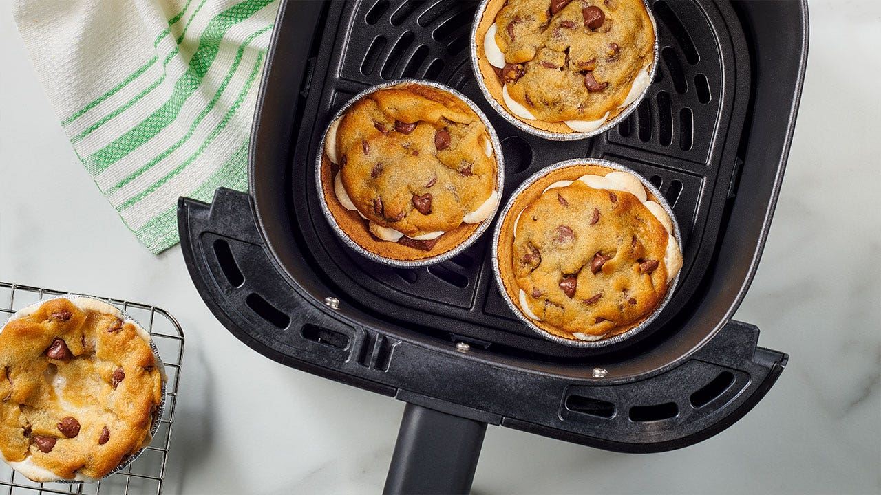 placing several mini pies into the air fryer to bake