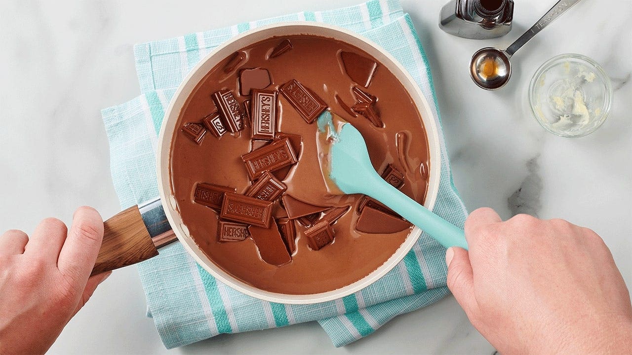 person stirring melted hersheys milk chocolate in a pot