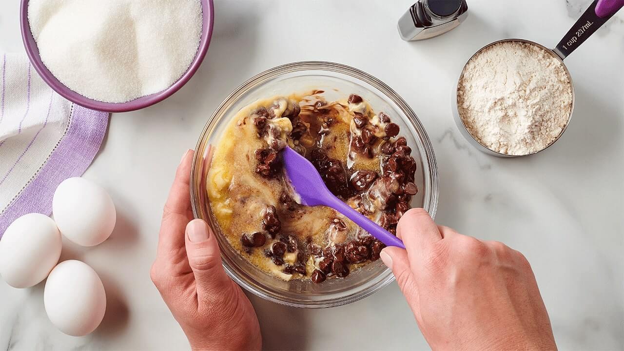 person mixing melted butter and hersheys chocolate chips together