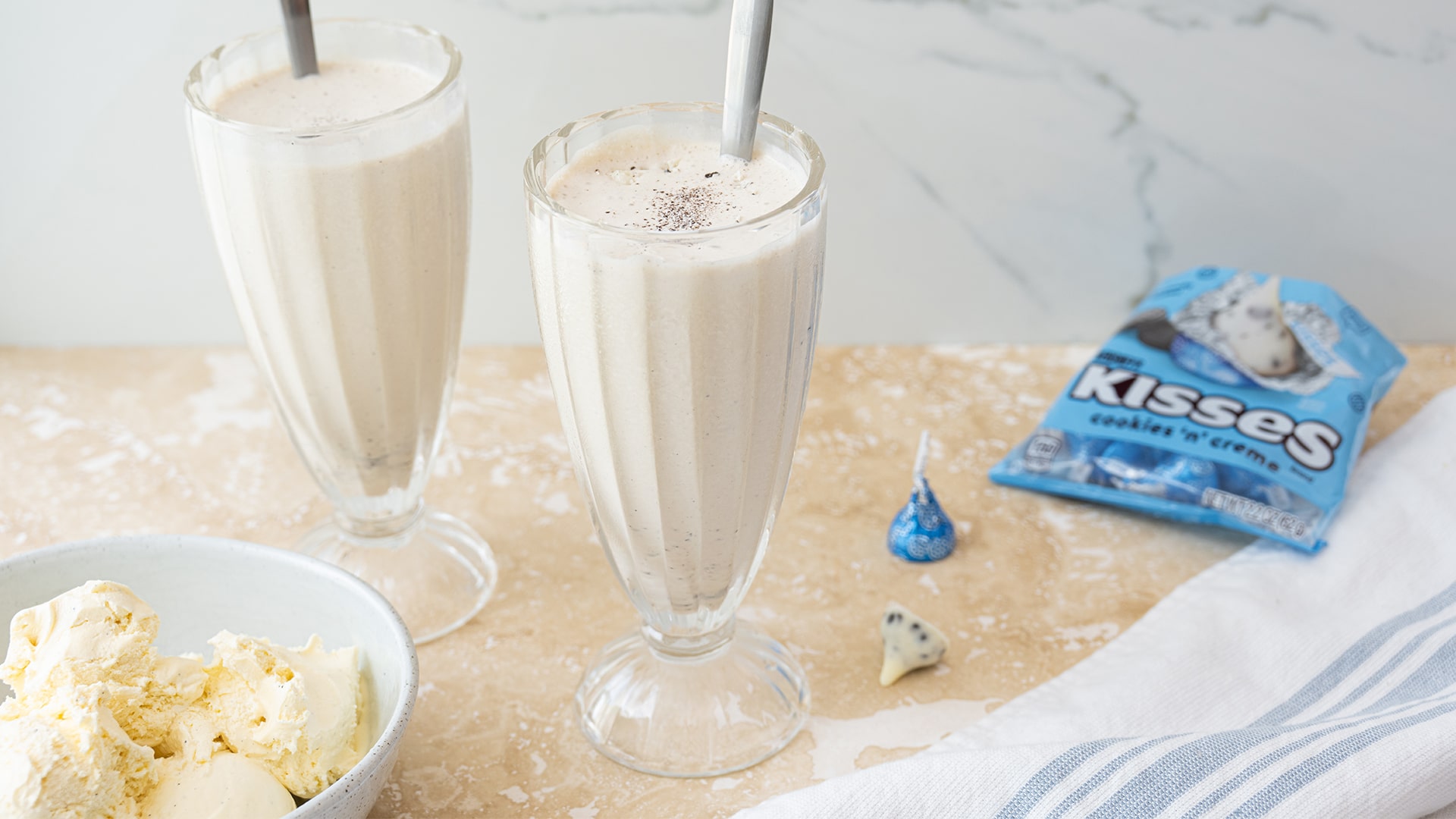 two cookies n creme milkshakes by a bowl of ice cream