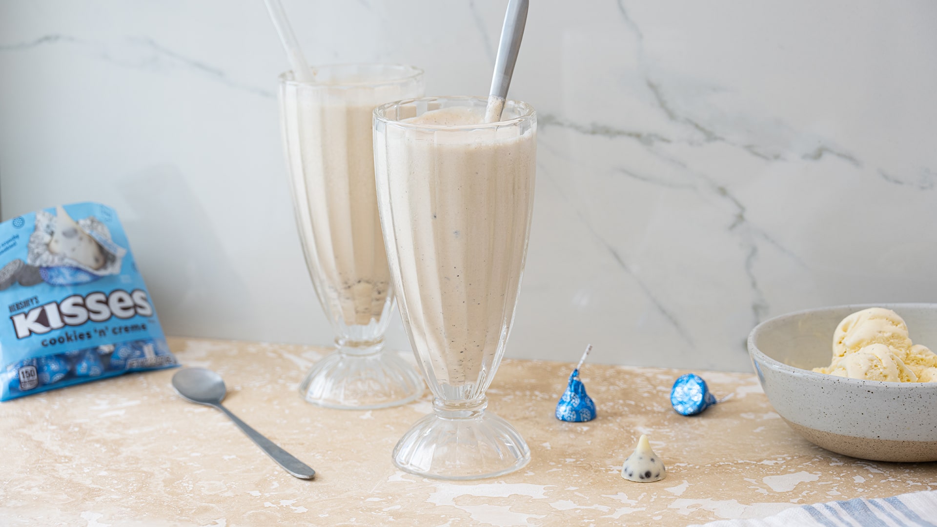 two cookies n creme milkshakes by a bowl of ice cream
