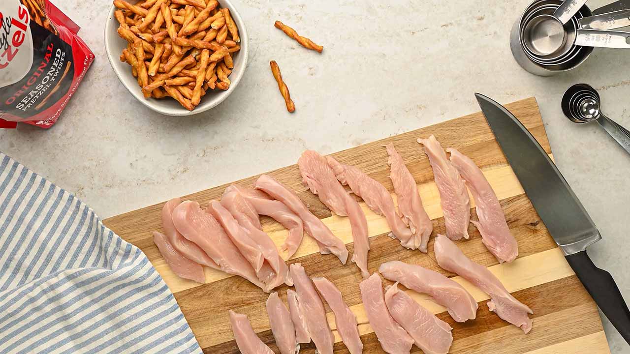 cutting up chicken breast into thin strips