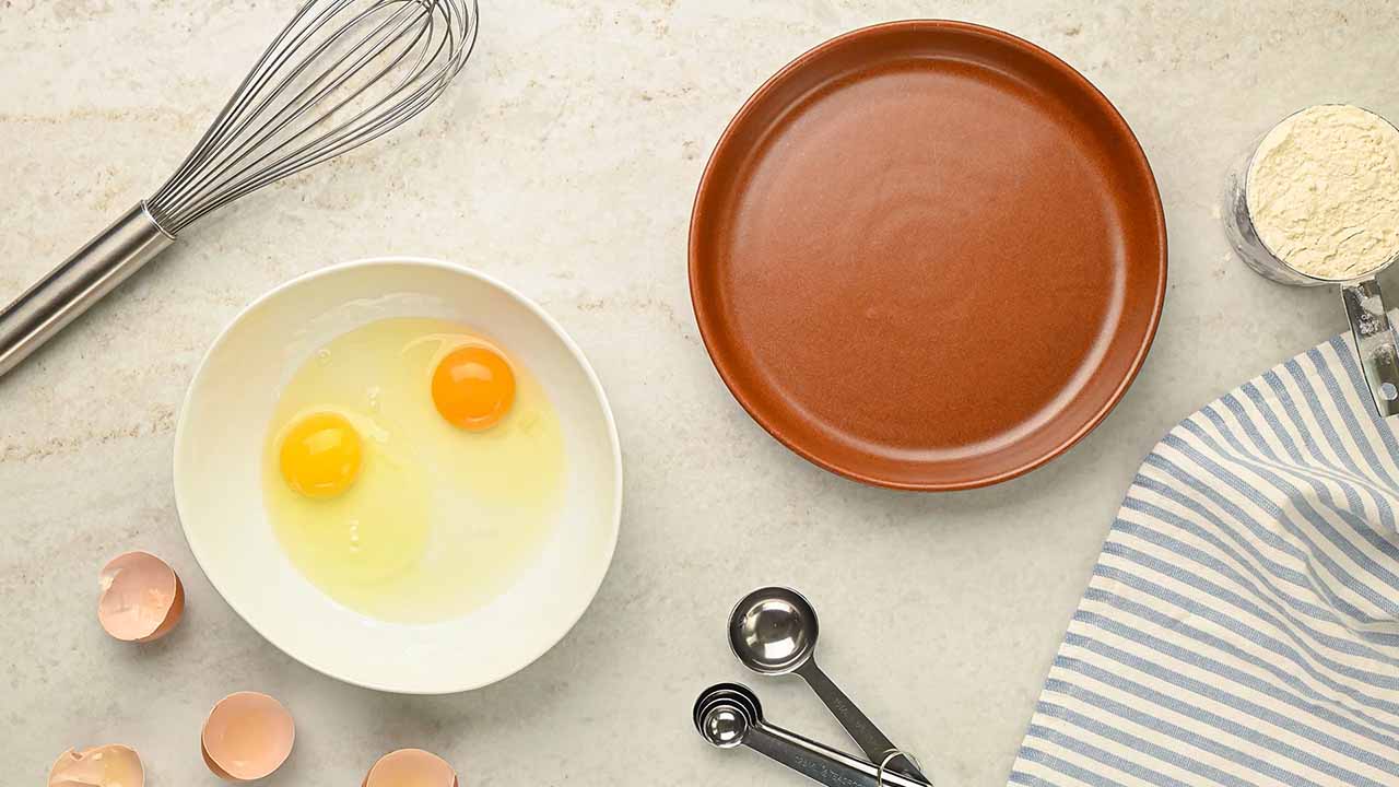 mixing together eggs and water in a small bowl
